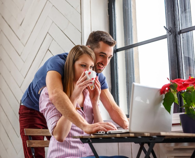 A man and a woman working with laptop at the table.