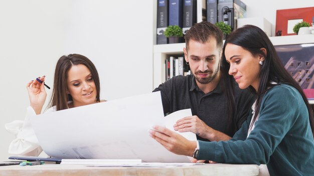 Man and women with blueprint in office