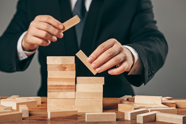 Man and wooden cubes on table. Management concept