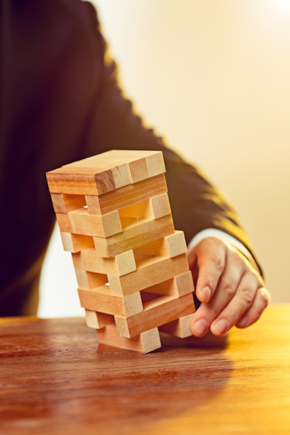 Man and wooden cubes on table. Management concept