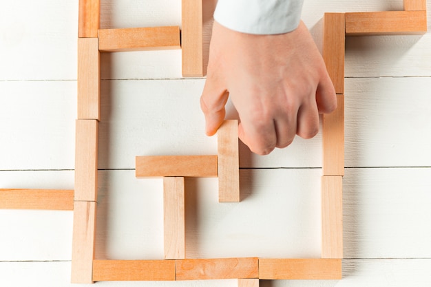 Free photo man and wooden cubes on table. management concept