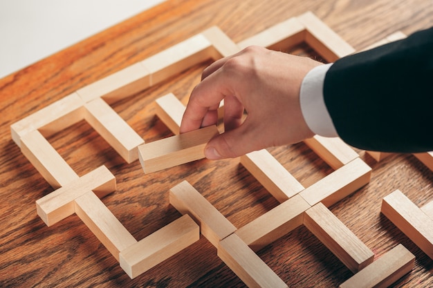 Man and wooden cubes on table. Management concept