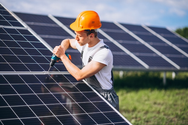 Man worker in the firld by the solar panels