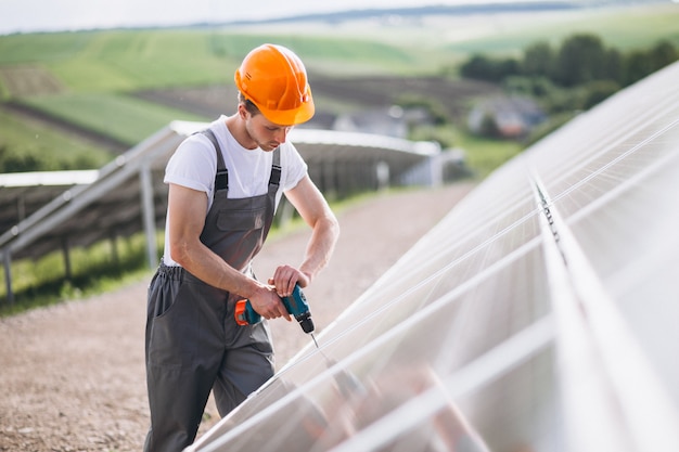 Man worker in the firld by the solar panels