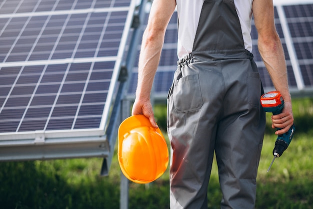 Man worker in the firld by the solar panels