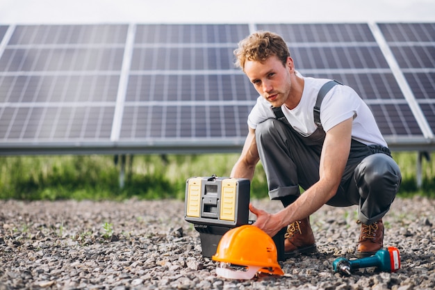 Man worker in the firld by the solar panels