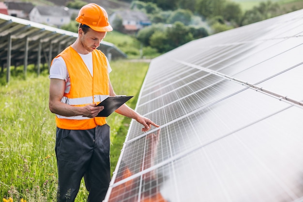 Man worker in the firld by the solar panels