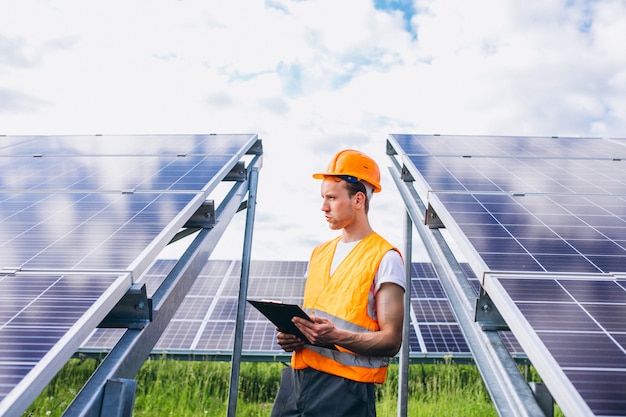 Man worker in the firld by the solar panels