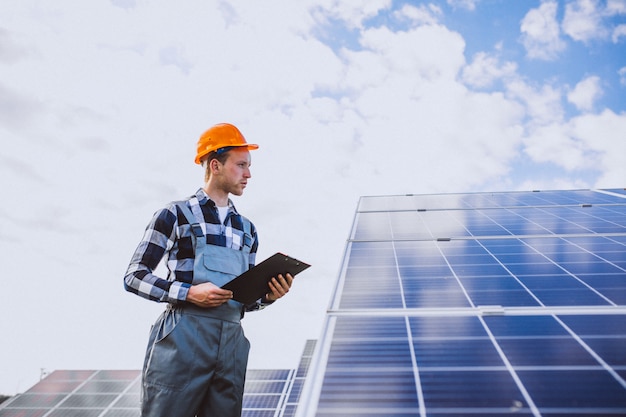 Man worker in the firld by the solar panels