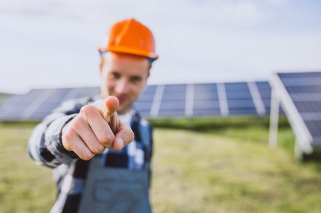 Man worker in the firld by the solar panels