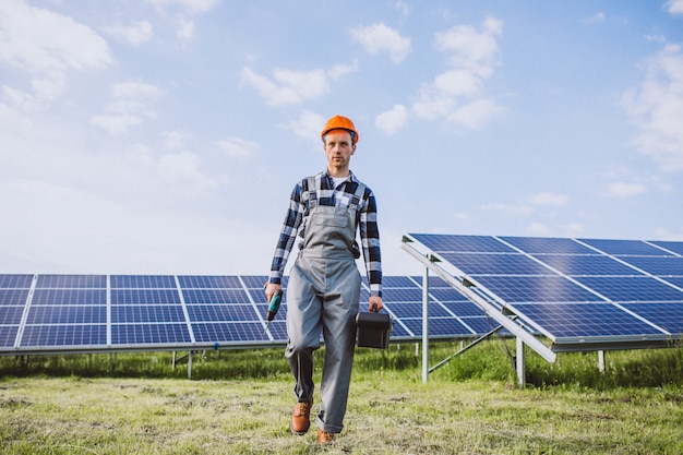 Free photo man worker in the firld by the solar panels