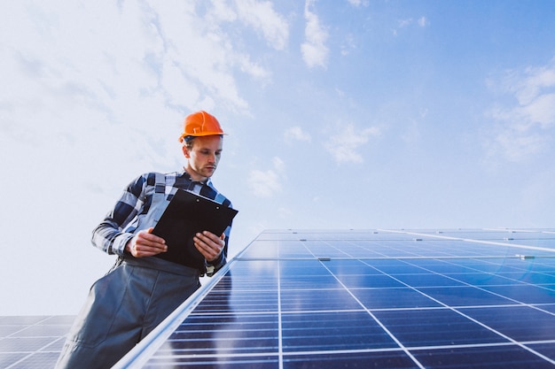 Man worker in the firld by the solar panels