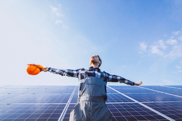 Man worker in the firld by the solar panels