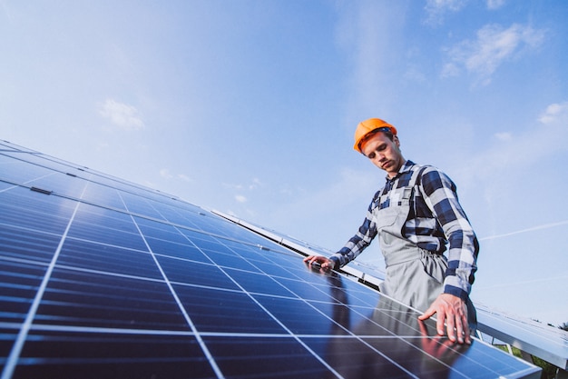 Man worker in the firld by the solar panels