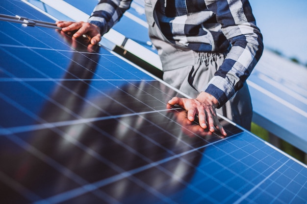 Man worker in the firld by the solar panels