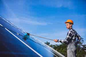 Free photo man worker in the firld by the solar panels