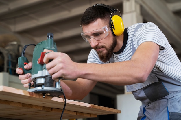 Free photo man working on cutting mdf board