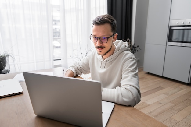 Man working from home at desk with laptop