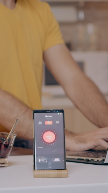 Free Photo man working from home with automation lighting system using voice controlled on smartphone turning on the light