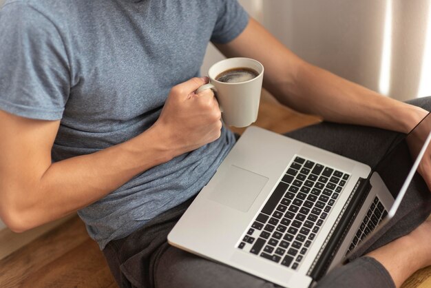 Man working at home during quarantine with coffee and laptop