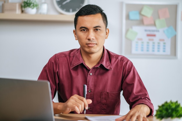 A man working in office with papers and laptop on desk