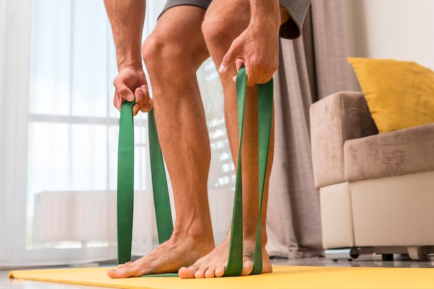 Free Photo man working out at home using elastic band