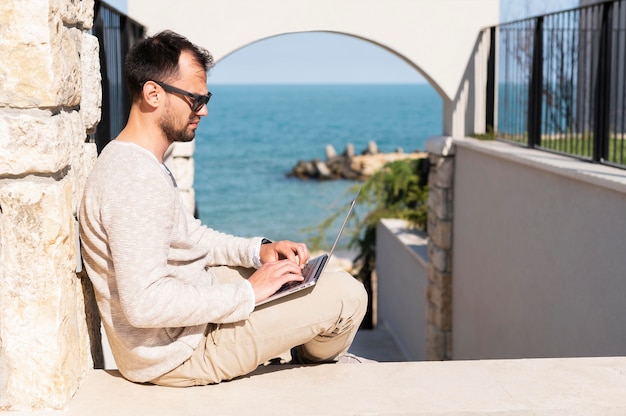 Free photo man working outdoors near the beach