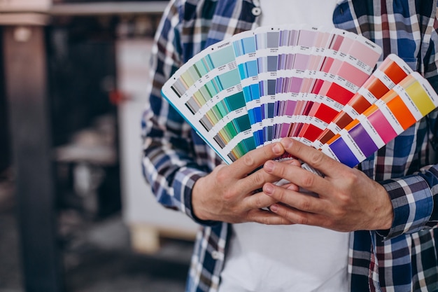 Man working in printing house with paper and paints