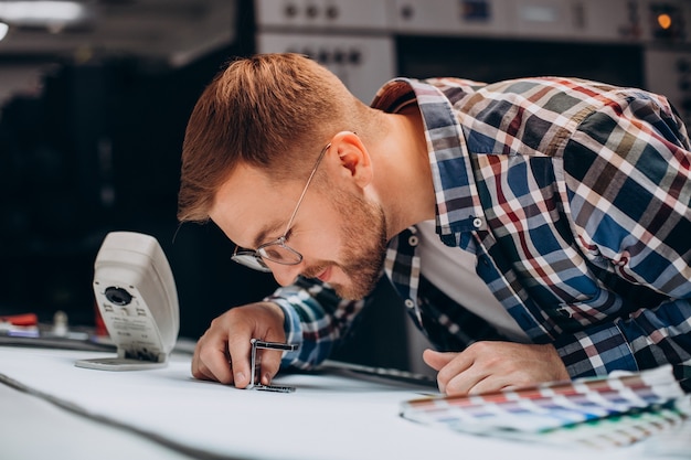 Man working in printing house with paper and paints