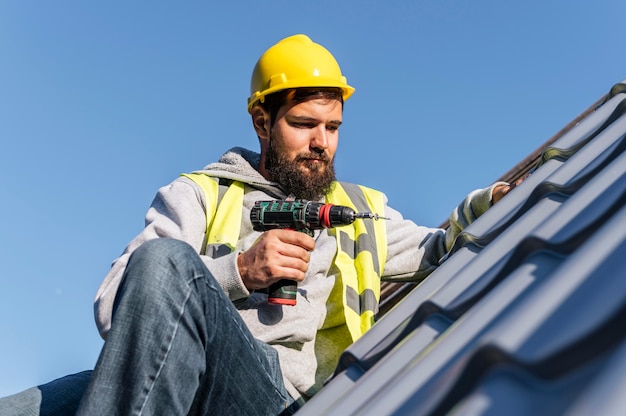 Free photo man working on roof front view