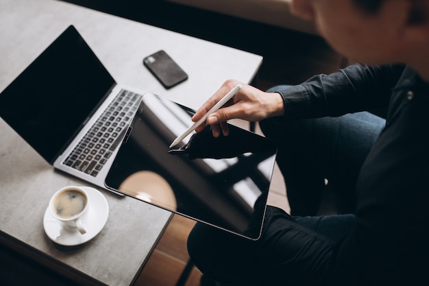 Man working on tablet close up at the table