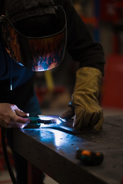 Free photo man working with argon welding machine in a garage