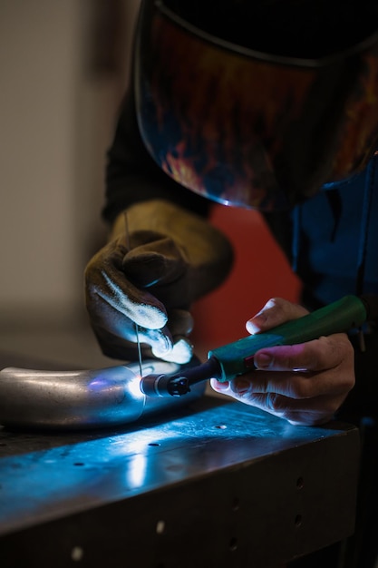 Free photo man working with argon welding machine in a garage