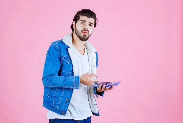 Man working with calculator and looks confused