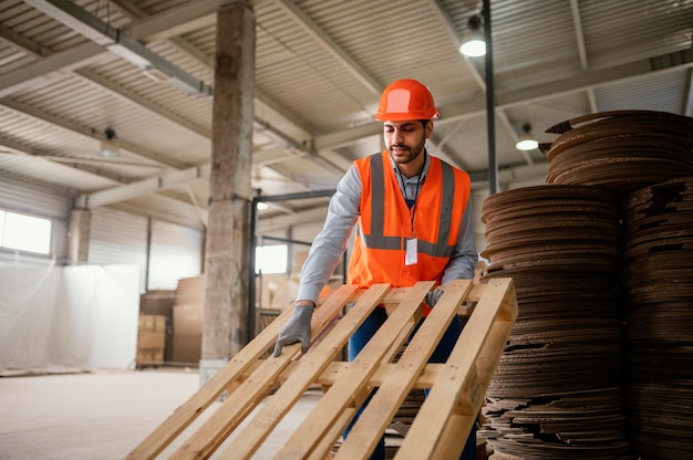 Man working with heavy wooden materials