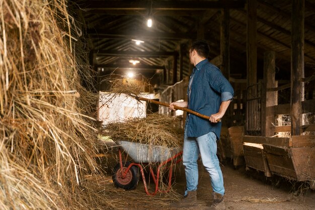 Man working with pitchfork side view