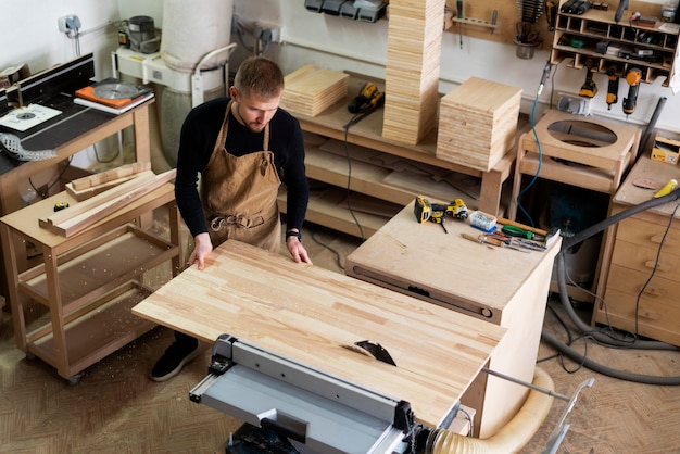 Free photo man working in a wood engraving workshop