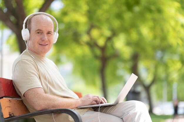 A man works on a laptop in the park