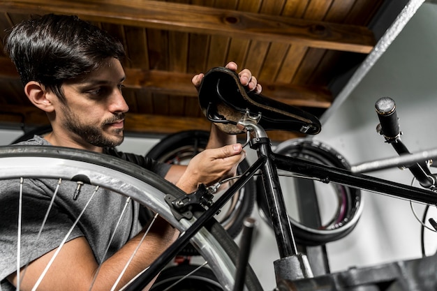 Free photo man in workshop creating bike