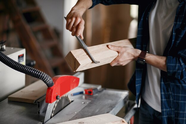 Man in the workshop with a wood