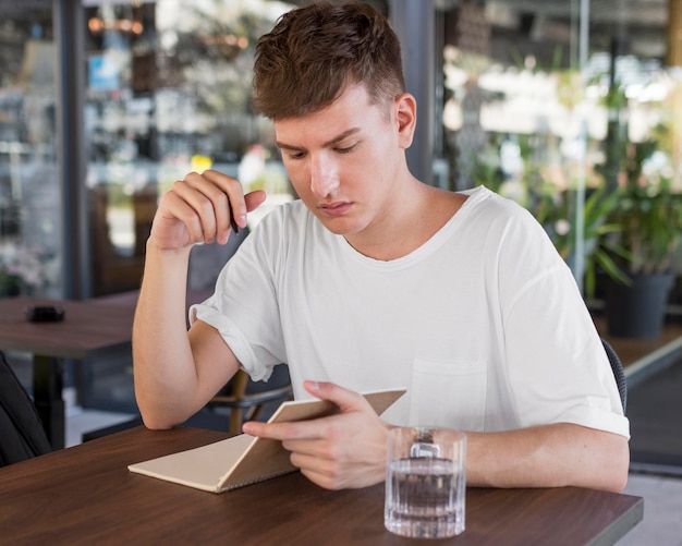 Man writing outdoors at pub