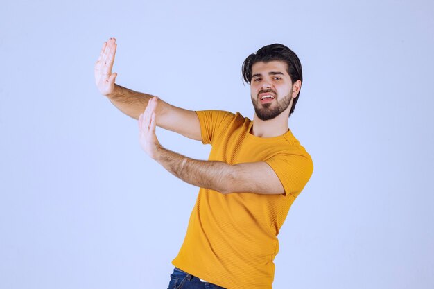 Man in yellow shirt stopping something