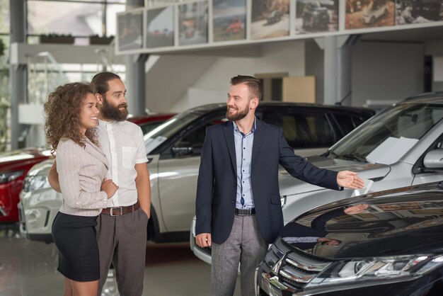 Manager of car center showing car to clients