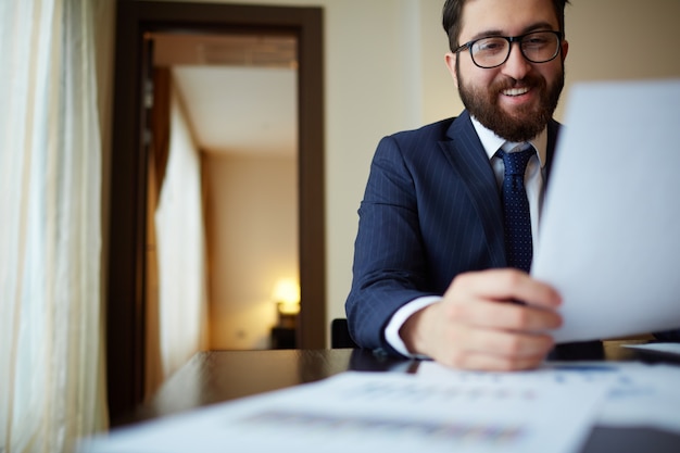 Free photo manager reading a document and laughing