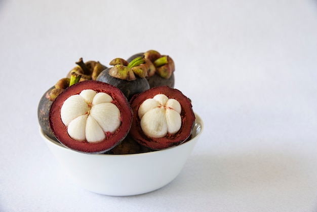 Free photo mangosteen thai popular fruits - a tropical fruit with sweet juicy white segments of flesh inside a thick reddish-brown rind.