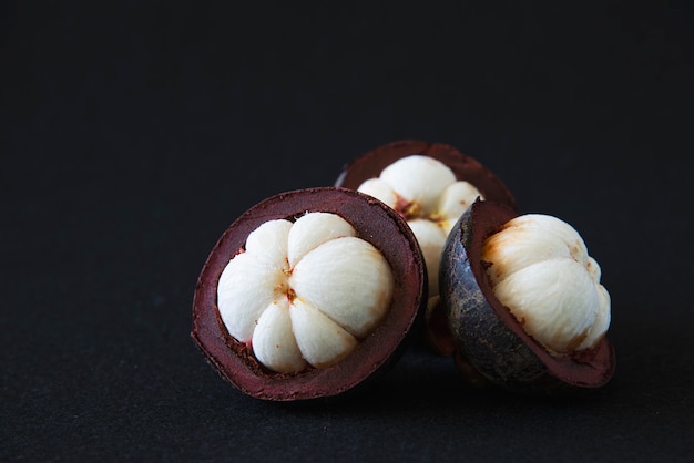 Free photo mangosteen thai popular fruits - a tropical fruit with sweet juicy white segments of flesh inside a thick reddish-brown rind.