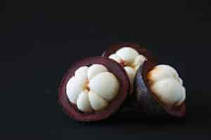 Free photo mangosteen thai popular fruits - a tropical fruit with sweet juicy white segments of flesh inside a thick reddish-brown rind.