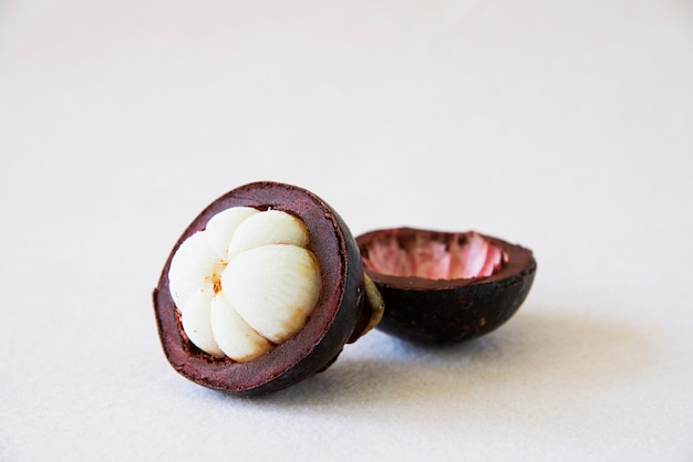 Free photo mangosteen thai popular fruits - a tropical fruit with sweet juicy white segments of flesh inside a thick reddish-brown rind.