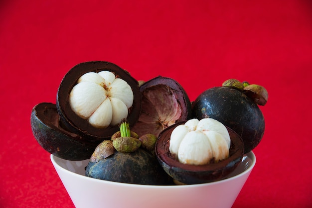 Free photo mangosteen thai popular fruits - a tropical fruit with sweet juicy white segments of flesh inside a thick reddish-brown rind.