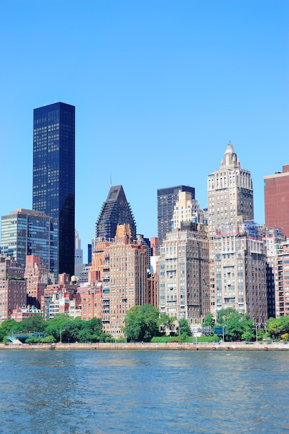 Manhattan midtown skyline panorama over East River with urban skyscrapers and blue sky in New York City